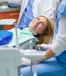 photo of a sedation dental patient who is smiling up at the dental hygienist