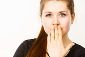 Woman hiding her mouth with her left hand