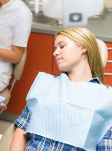 Woman asleep in a dental chair from a sedation dentist