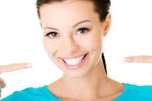 Woman pointing at her white smile.