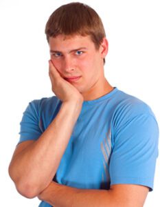 Man holding his jaw in need of an emergency dentist