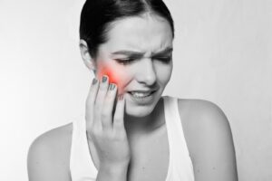 Woman in pain and in need of an emergency dentist